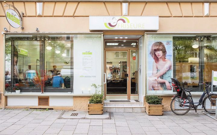 Haidhausen: der Laden von außen, Wörthstraße 40, mit Pflanzkübeln und Fahrrad vor dem Fenster.