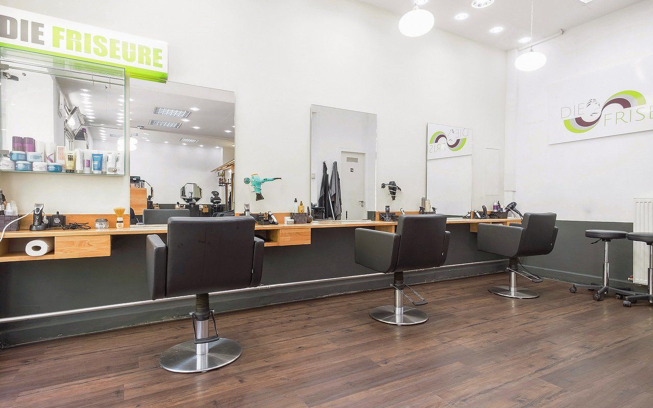 Der Salon in Haidhausen: schwarze Lederstühle vor der Eichenablage, darüber Spiegel, dahinter die Fenster zur Wörthstraße.